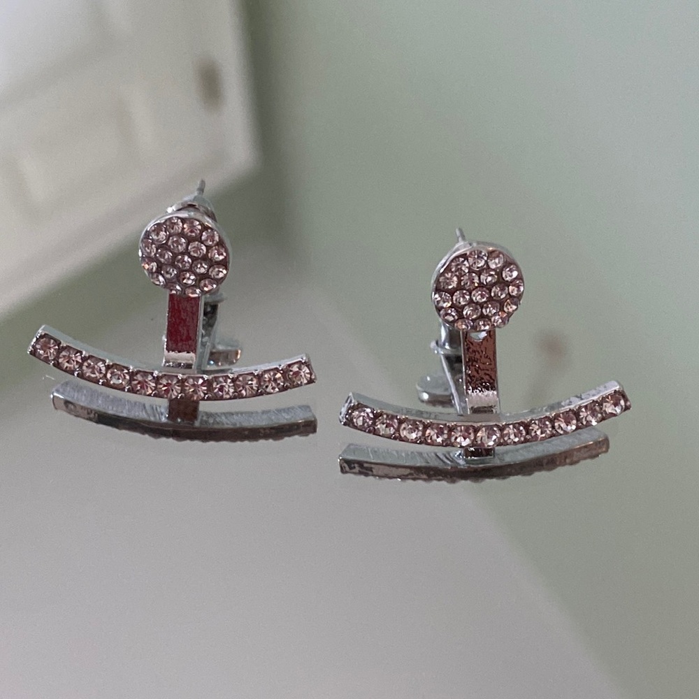 Silver stud earrings with a silver jacket cuff